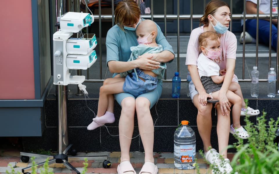 Women hold patients at Ohmatdyt Children's Hospital that was damaged during Russian missile strikes, in Kyiv